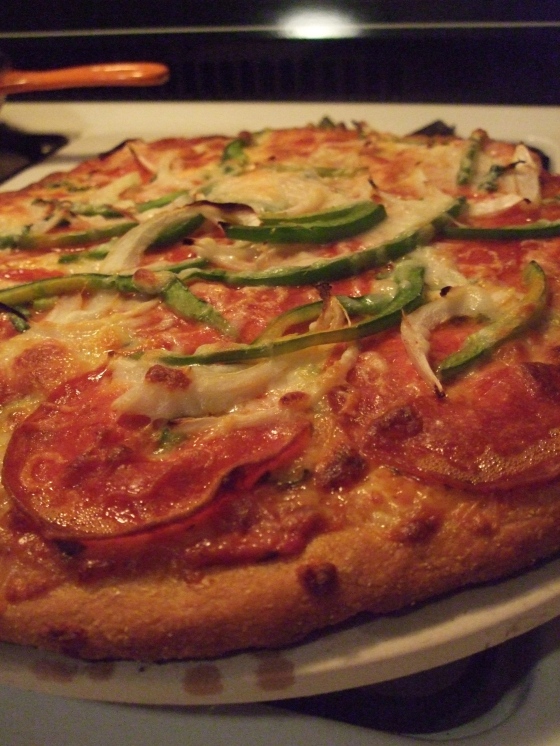Completely homemade pizza, Alex's creation. White whole wheat crust, with a tomato-basil-garlic chunky sauce, topped with whole-milk mozzarella, spinach, green pepper, onion, and giant pepperoni. Divinely cooked atop a cornmeal-rubbed pizza stone...for the perfect crust.